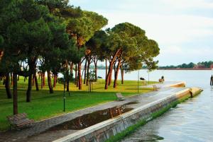 un parque con bancos y árboles junto a un cuerpo de agua en Venezia Vaniglia Guest House en Venecia