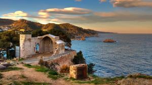 an old building on the shore of a body of water at Lets Holidays apartment Sant Miquel in Tossa de Mar