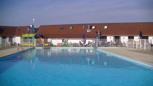a large blue swimming pool in front of a building at maison de dunes in Bredene