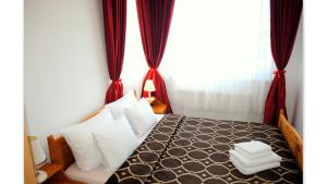 a bedroom with a bed with white pillows and a window at Veda Guest House in Pomorie