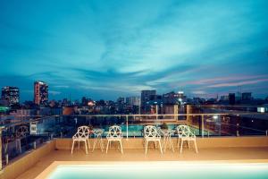 a group of chairs sitting on a balcony with a city skyline at Prague Hotel in Ho Chi Minh City