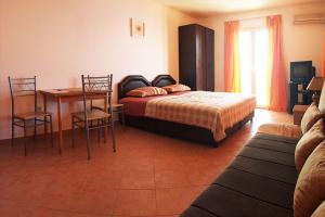 a bedroom with a bed and a table and chairs at Villa Palma Ceoce in Budva