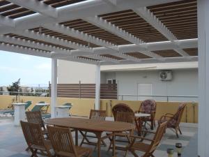 a patio with a wooden table and chairs at La Santre Villa in Amoudara Herakliou