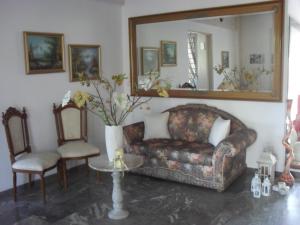 a living room with a couch and a mirror at La Santre Villa in Amoudara Herakliou