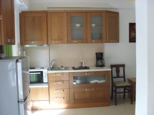 a kitchen with wooden cabinets and a refrigerator at La Santre Villa in Amoudara Herakliou