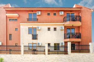 a large orange building with balconies and a fence at Vila Patricia in Eforie Sud
