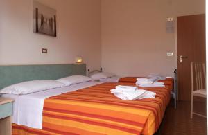 Dos camas en una habitación de hotel con toallas. en Albergo Santo Stefano, en Bellaria-Igea Marina
