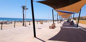 グアルダマル・デル・セグラにあるApartamento Guardamar Playaの傘下に座る人々の砂浜