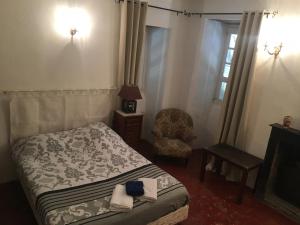 1 dormitorio con 1 cama, 1 silla y 1 ventana en Chambres A Casa De Giovanni à Pietra-di-Verde en Haute-Corse en Pietra-di-Verde