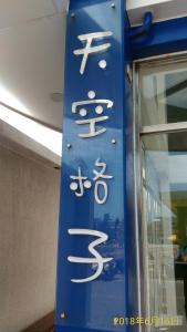 馬公市的住宿－天空格子民宿 ，建筑一侧带有亚洲文字的蓝色标志