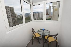 a small table and two chairs in a room with windows at Apartment Ćukušić in Split