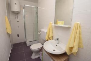a bathroom with a sink and a toilet and a shower at Apartment Ćukušić in Split