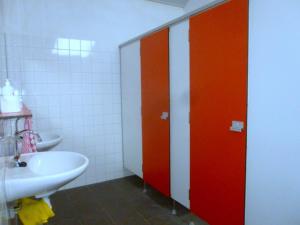 een badkamer met twee rode deuren en een wastafel bij De Stadsgaten in Rouveen