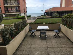 a table and chairs on a patio near the ocean at Chez Fany et Ben in Cabourg +7 photos