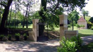 een poort in een park met bomen en een veld bij Domaine Jean-Got, proche de Saint Emilion in Lugaignac