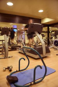 a gym with several tread machines and people in the background at Hotel Real Oeiras in Oeiras