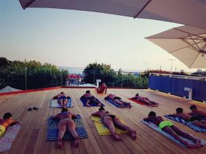 a group of people laying on mats at the beach at Hotel Intervallo in Torre Lapillo