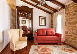 a living room with a red couch and a chair at Cal Tomas, Ecoturisme Terra Alta in Bot