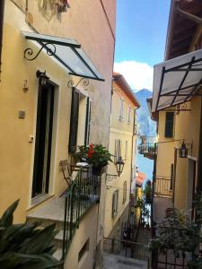 eine Gasse mit Gebäuden und einen Balkon mit Blumen in der Unterkunft Appartamento 4 pass in Varenna