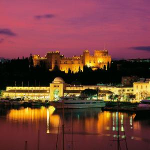 a large castle is lit up at night at Maximos Sea & The City in Rhodes Town