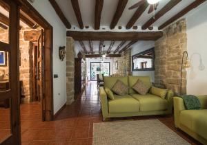 a living room with a green couch and a hallway at Cal Tomas, Ecoturisme Terra Alta in Bot