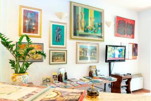 a room with a table with a tv and pictures on the wall at Hotel Ristorante da Carlos in Santa Maria del Giudice
