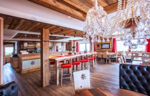 a restaurant with a bar with wooden floors and a chandelier at Berggasthof Edelweiss in Ebensee