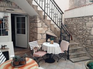 una mesa y sillas en un patio con una pared de piedra en Apartments Ani en Vela Luka