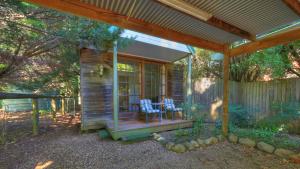 uma pequena cabina com uma mesa e cadeiras num alpendre em Chalets Lumineux em Bright