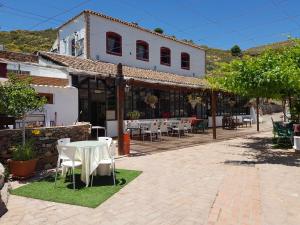 a patio with a table and chairs in front of a building at Las Tres Patas Complejo Rural in Enix