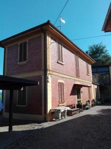 un gran edificio de ladrillo rojo con porche en B&B "Il Cantastorie" Casa Molinari-Boldrini - Room & breakfast, en Castelfranco Emilia