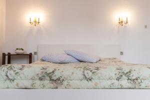モントーバンにある46FM : Montauban Guest Houseのベッド1台(枕2つ、壁に照明2つ付)