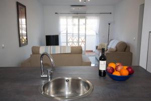 Un fregadero de cocina con un bol de fruta y una botella de vino. en Puerto de la duquesa beach apartment, en Castillo de Sabinillas