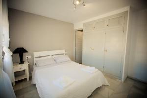 Un dormitorio con una cama blanca con toallas. en Puerto de la duquesa beach apartment, en Castillo de Sabinillas 22 fotos más