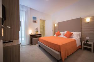 pokój hotelowy z łóżkiem z pomarańczowym kocem w obiekcie Hotel Simi Lan w Lignano Sabbiadoro