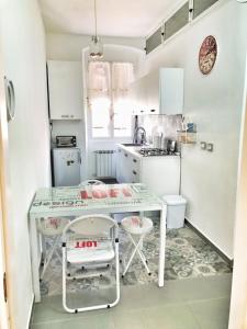 uma pequena cozinha branca com mesa e cadeiras em Tino'S House em La Spezia