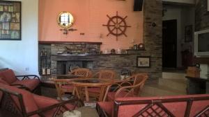 a restaurant with tables and chairs and a fireplace at Cavo Paradiso Villa in Asprovalta
