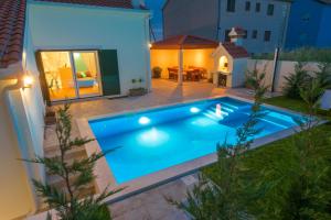 a swimming pool in the backyard of a house at night at Villa Lucia, peacefull and private in Mravince
