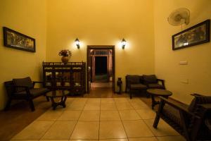 a waiting room with chairs and tables in a room at The Colonial Manek Manor in Mount Ābu