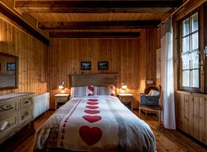 een slaapkamer met een bed met rode harten erop bij Chalet Silenthia in Ledro