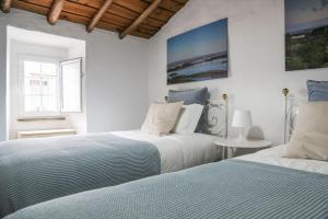 two beds in a bedroom with white walls at Sossego da Carminho in Monsaraz