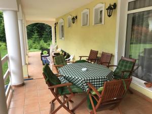 un patio con mesa y sillas en un porche en Silvanus Panzió, en Lenti