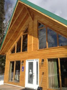 a house with large windows and a white door at Chalet d'Anna in Saint-Damien