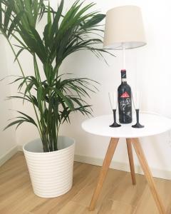 una pianta accanto a un tavolo con una bottiglia di vino di Le Tre Orchidee Florence a Firenze