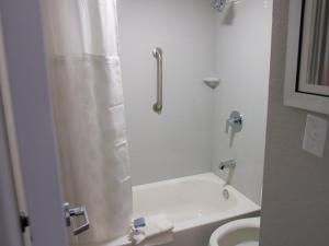 uma casa de banho com um chuveiro, um WC e um lavatório. em Wingate by Wyndham Louisville Airport Expo Center em Louisville