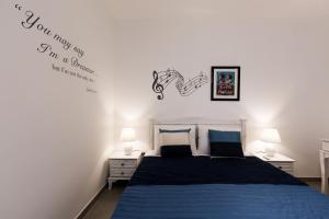 a bedroom with a bed with a blue bedspread at Ta Martin, Flat 2 in St. Paul's Bay