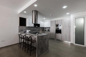 a kitchen with a sink and a counter with stools at Ta Martin, Flat 2 in St. Paul's Bay +11 photos