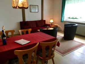 een woonkamer met een rode tafel en een bank bij Ferienpark Wehrda GmbH in Wehrda