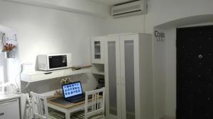 a room with a desk with a computer and a microwave at Split studio Irisha in Split