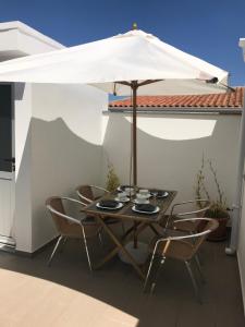 un tavolo e delle sedie sotto un ombrellone in un patio di Avenida a Praia de Mira